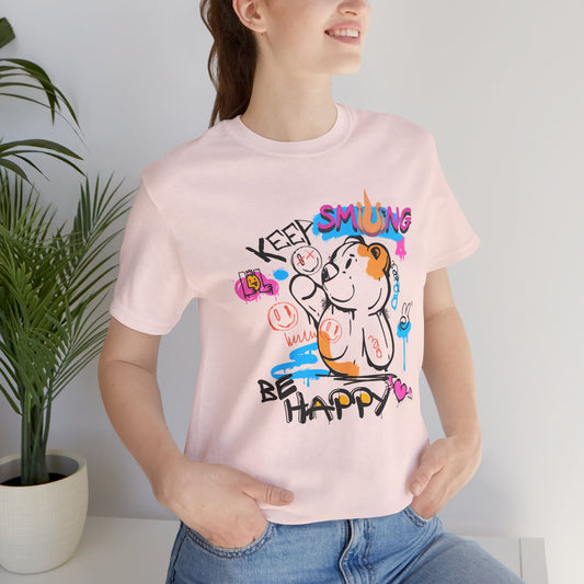 Person wearing a pink t-shirt with colorful graphics and text Keep Smiling Be happy