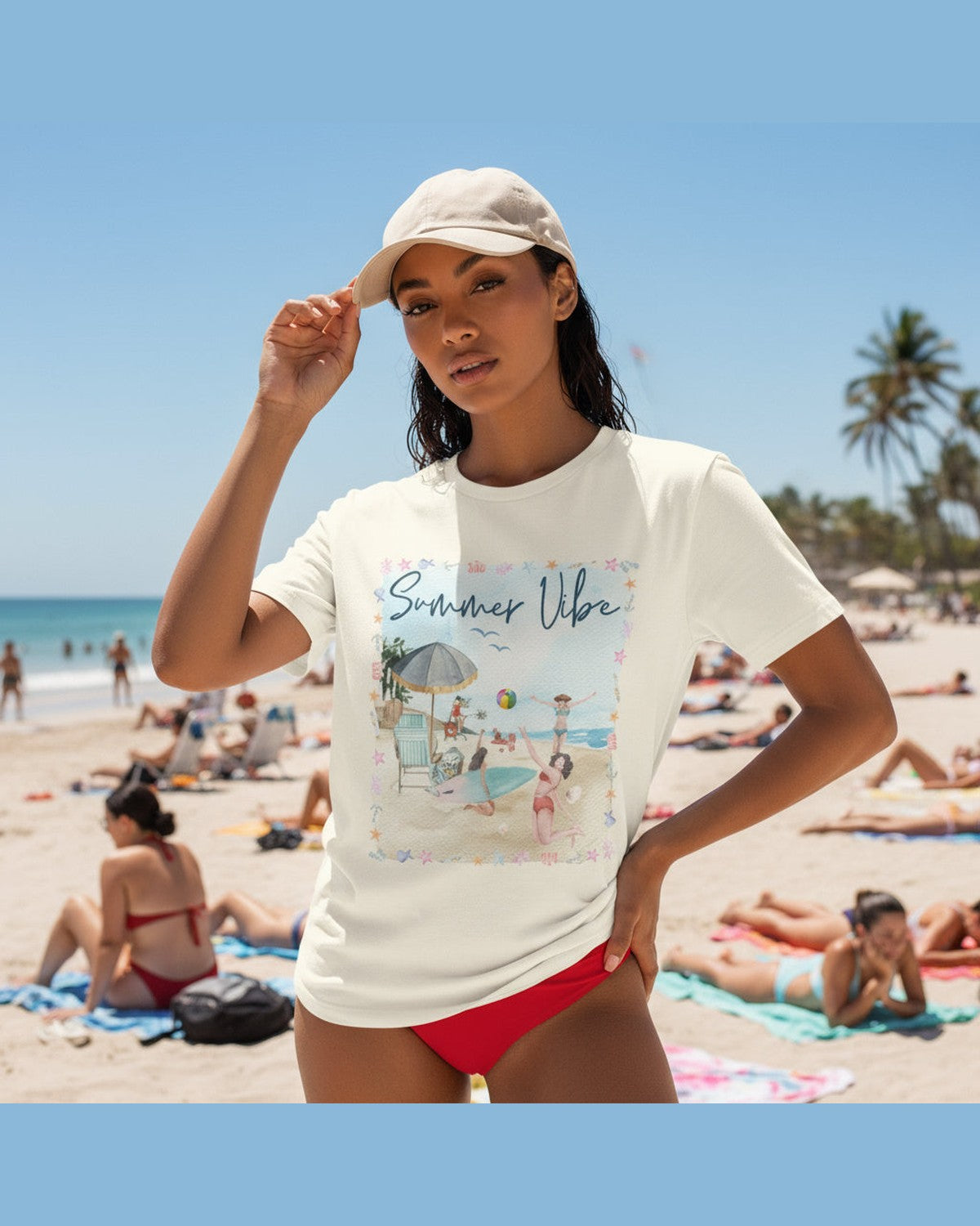 Woman wearing a yellow t-shirt and a hat with a 'Summer Vibes' graphic design posing on a lively beach 