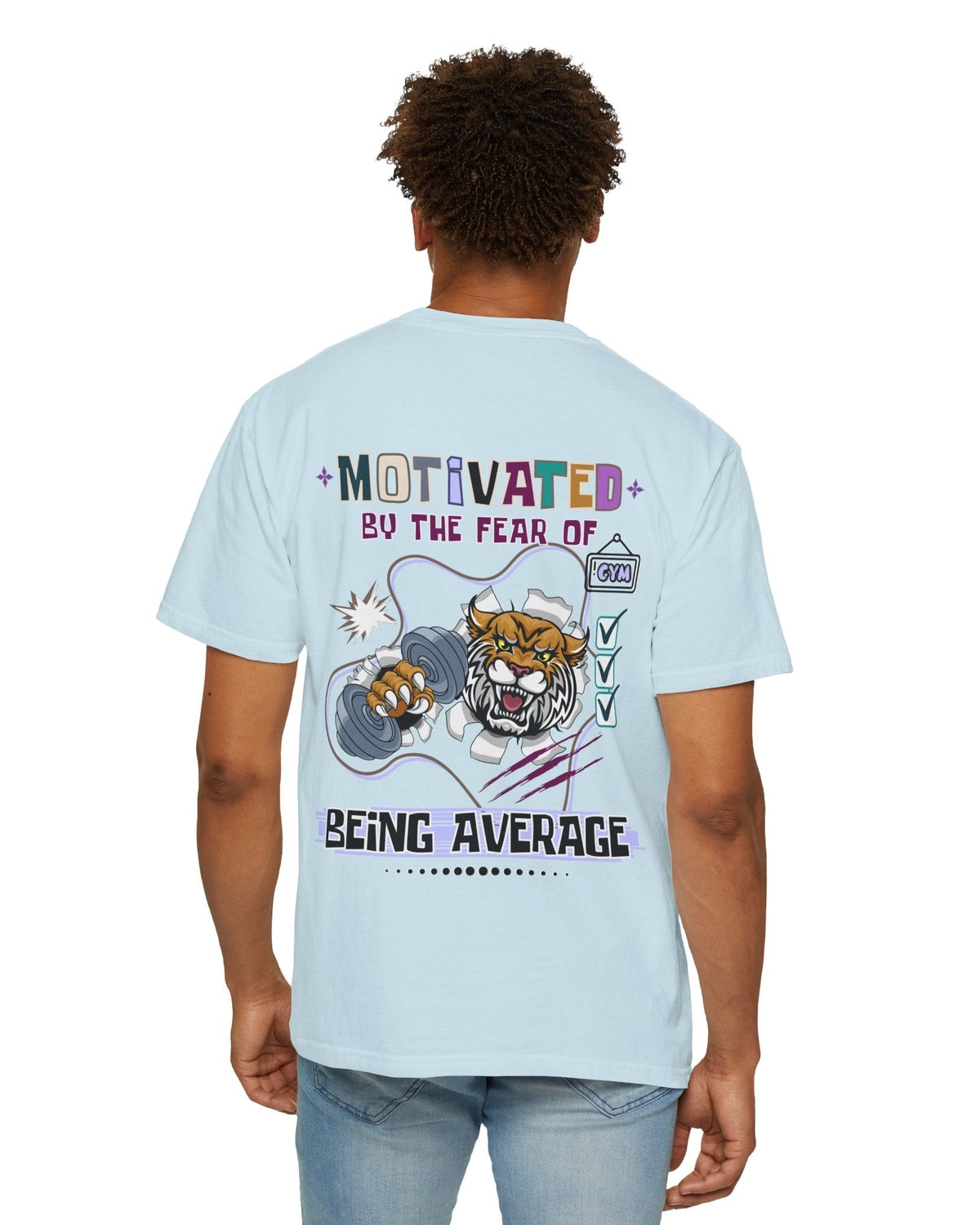 Person wearing a light blue t-shirt with a motivational graphic and text 'Motivated by the fear of being average' on the back.