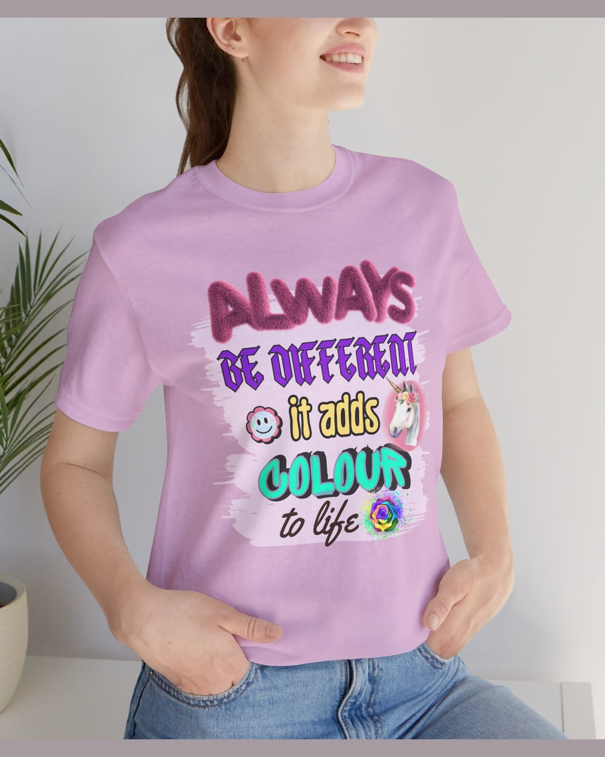 Person wearing a purple t-shirt with a motivational quote Always Be Different it adds colour to life and colorful text.