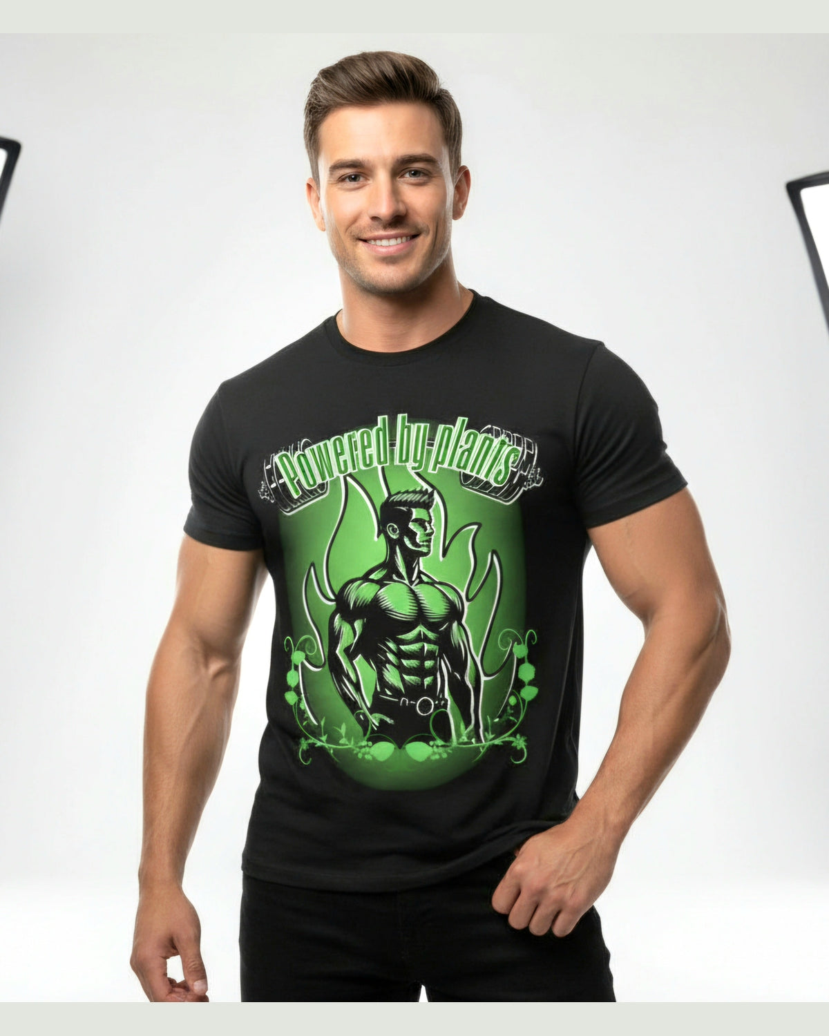 Man wearing a black t-shirt with a green vegan muscle man graphic design and a text Powered by Plants on a white background