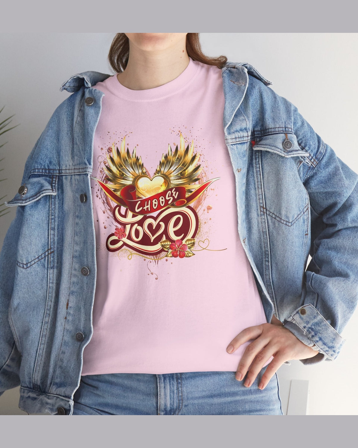 Person wearing a pink t-shirt with 'Choose Love' design and a denim jacket.