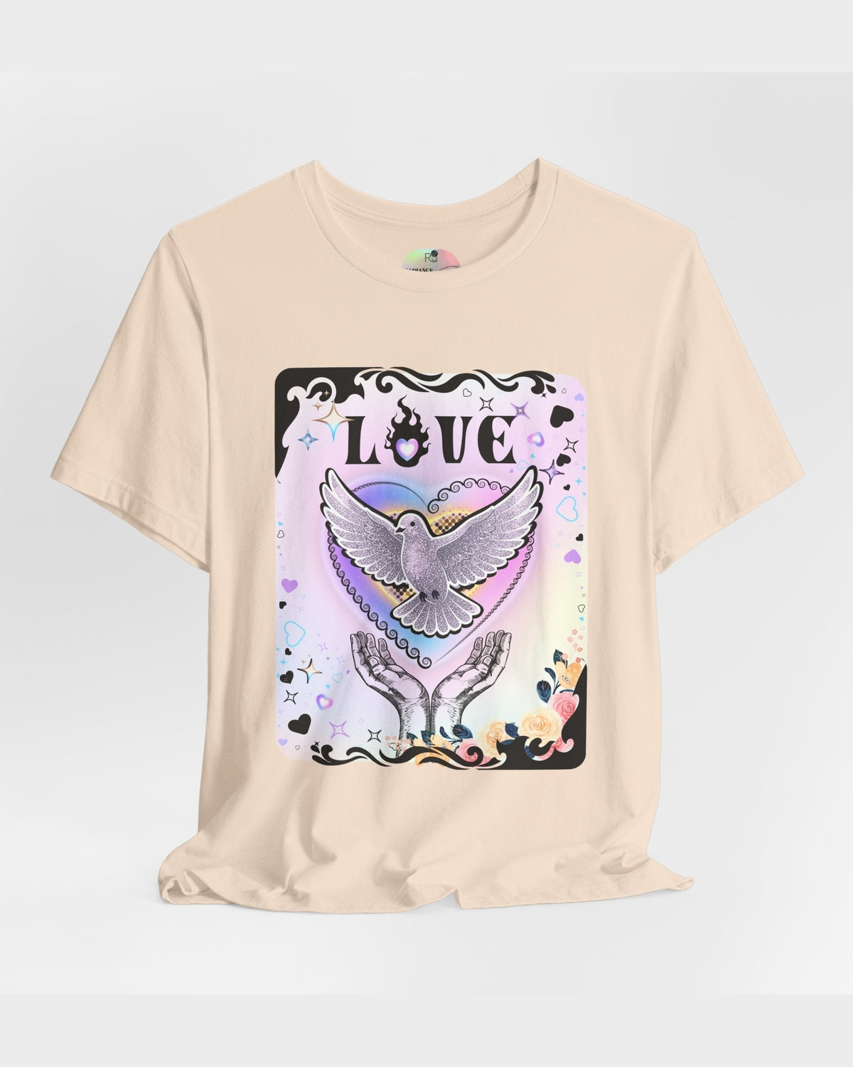 Soft cream tshirt with vibrant pink and purple pastel colours, flowers and a pigeon coming out of hands with the text Love on a grey background 