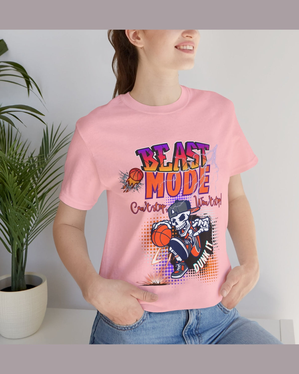 Person wearing a pink t-shirt with a motivational  quote 'Beast Mode Cant stop Wont stop' and a vibrant baseball graphic design.