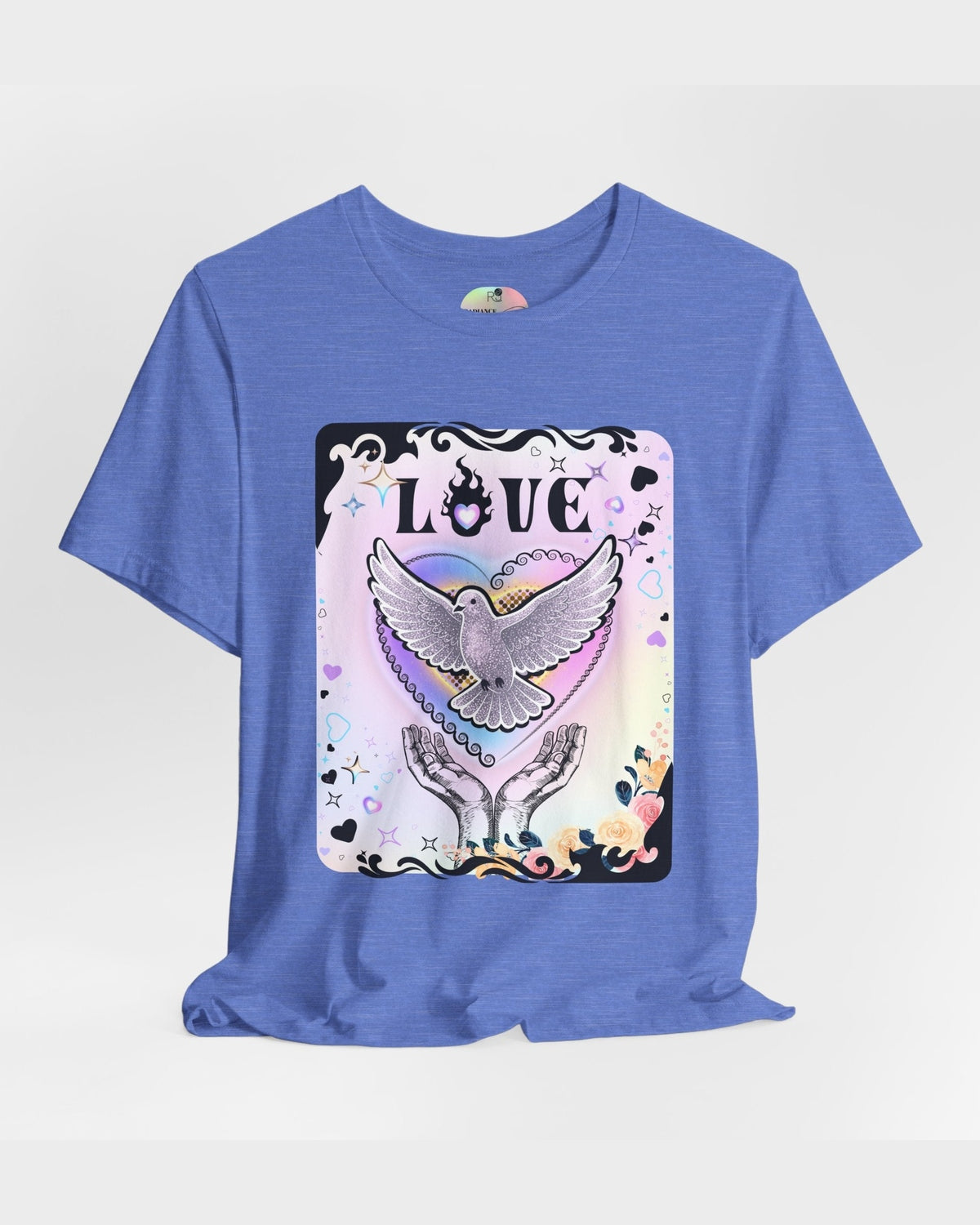 Blue tshirt with vibrant pink and purple pastel colours, flowers and a pigeon in rainbow heart coming out of hands with the text Love on a grey background 