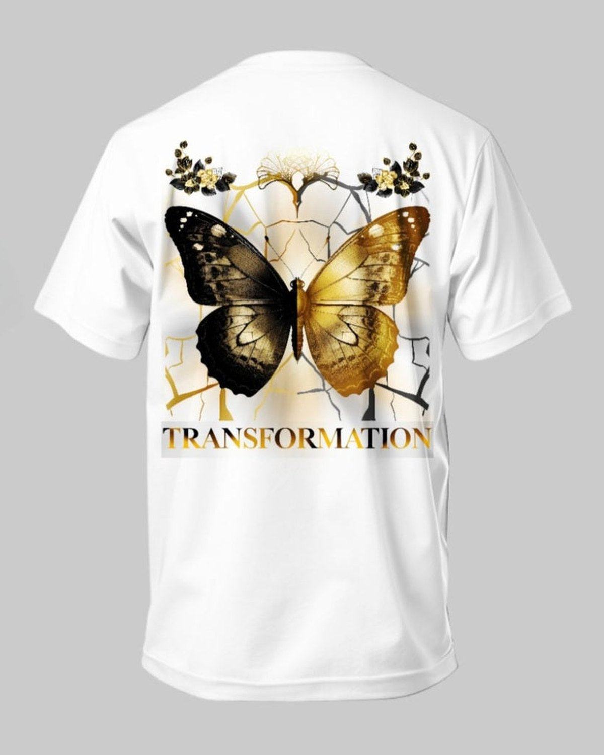 White t-shirt with a gold and brown butterfly design and 'TRANSFORMATION' text on a gray background