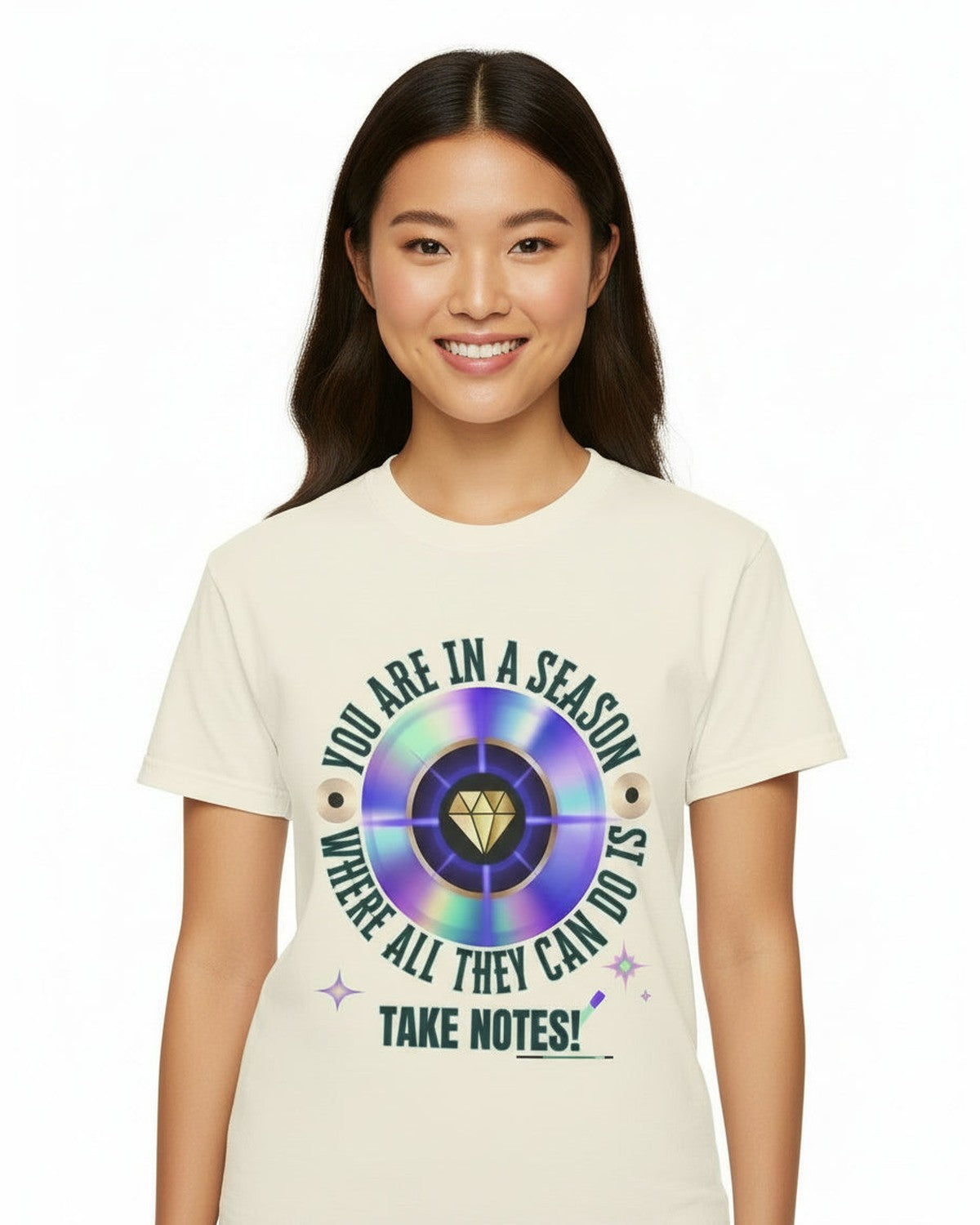 Person wearing a white t-shirt with a colorful graphic and text 'You are in a season where all they can do is take notes' on a white background