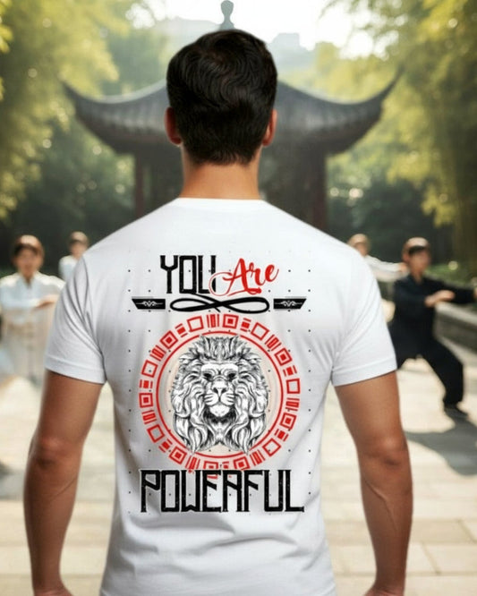 Person wearing a white t-shirt with a motivational quote 'You are Powerful' and lion graphic in an outdoor setting.