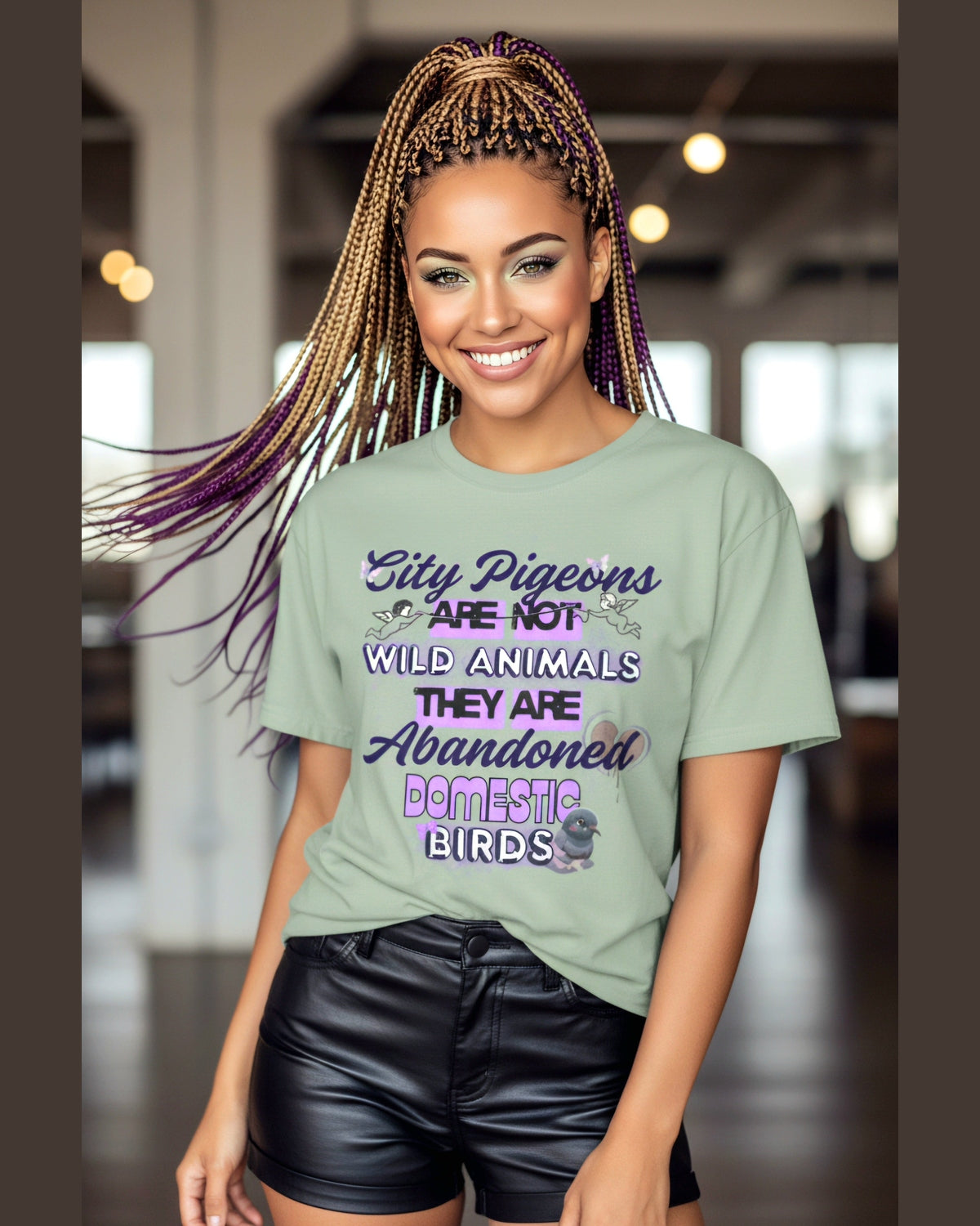 Woman wearing a green t-shirt with Pigeon Awareness text, standing indoors.