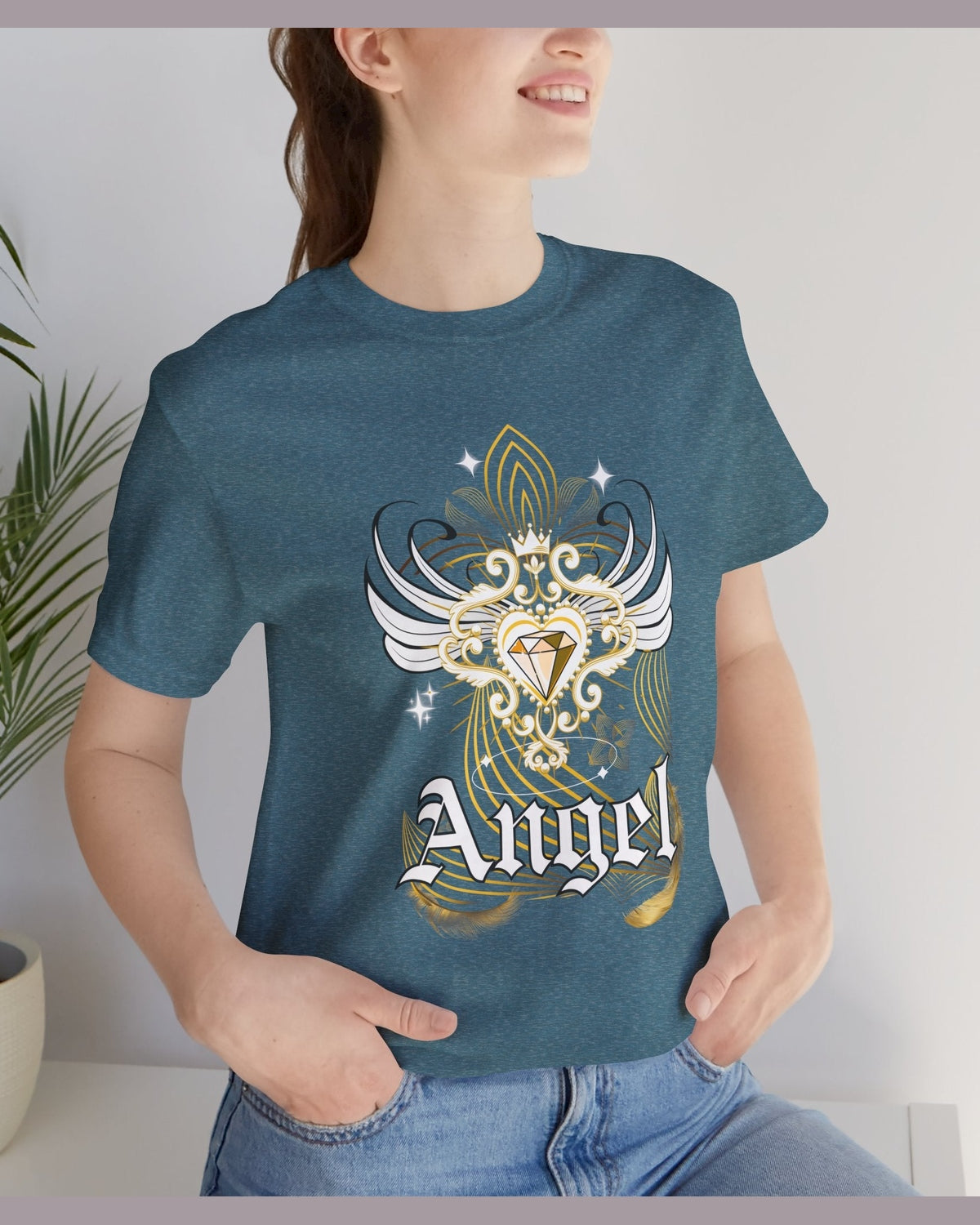 Person wearing a teal t-shirt with an angel design and the word 'Angel' on it, standing indoors.