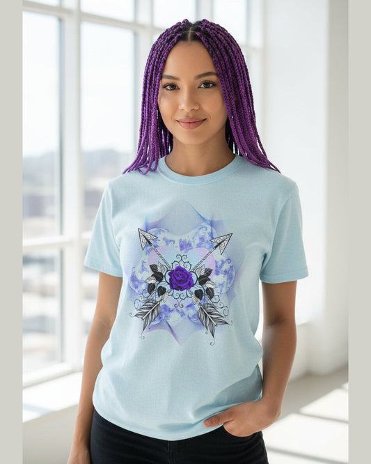 Person wearing a light blue t-shirt with a purple rose and arrow design, standing indoors 