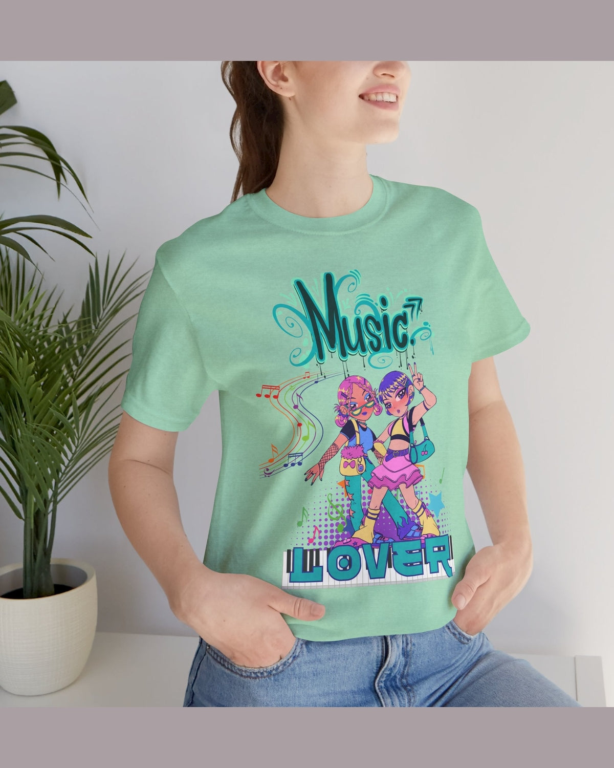 Person wearing a green t-shirt with a colorful graphic featuring two dancing Anime girls design, and 'Music Lover' text.