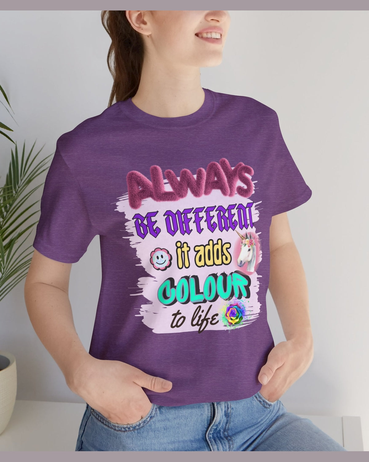 Person wearing a purple t-shirt with colorful inspirational text Always Be Different graphics.