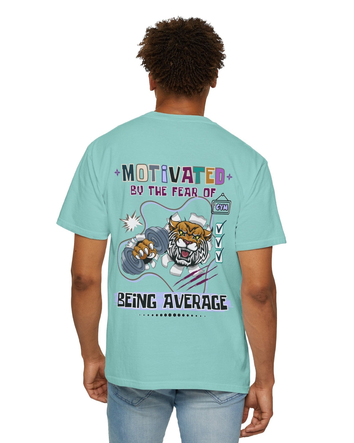 Person wearing a light blue t-shirt with a tiger graphic and motivational text 'Motivated by the fear of being average' on the back.