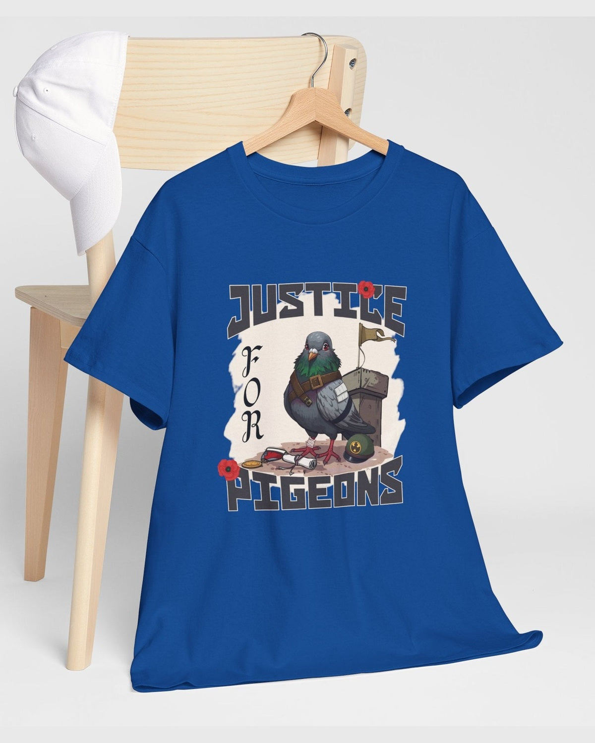 Blue t-shirt with 'Justice for Pigeons' graphic on a wooden chair.