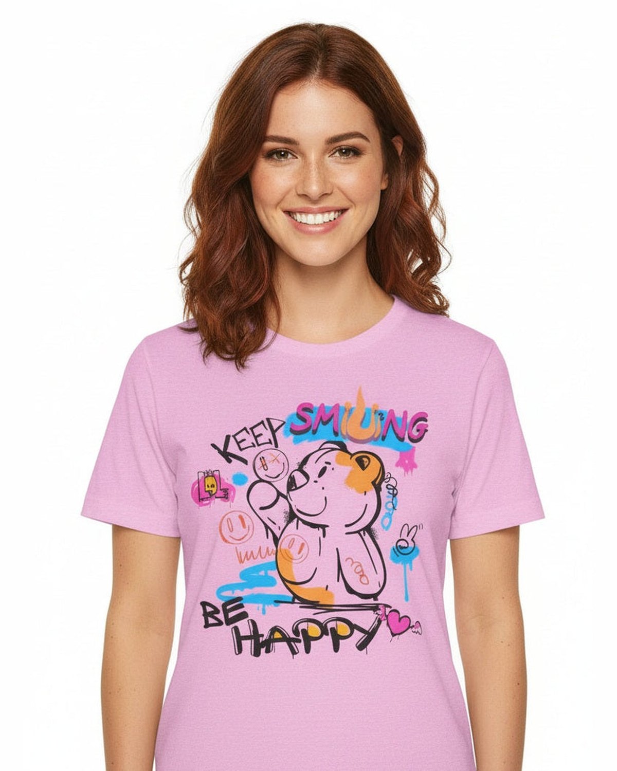 Woman wearing a pink t-shirt with a cartoon bear and grafitti design and text Keep Smiling, Be Happy on a white background