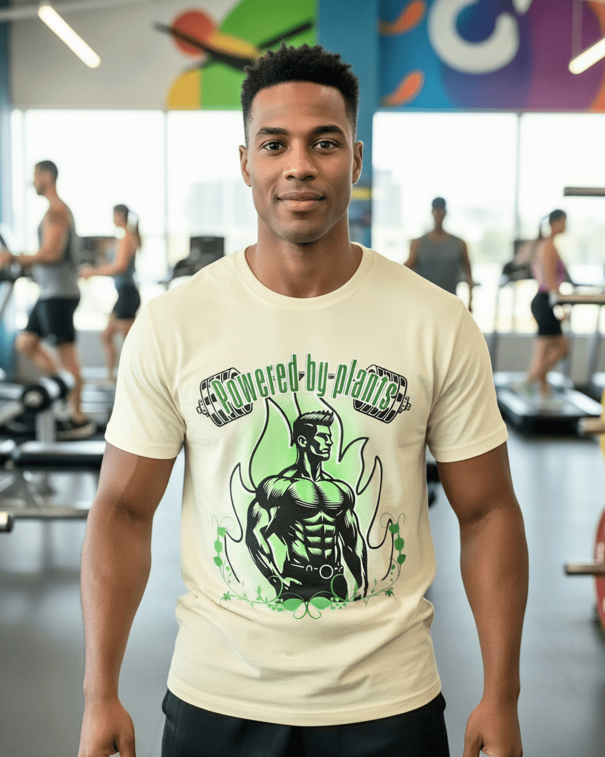 Man wearing a soft yellow t-shirt with a vegan muscle man graphic design and a text Powered by Plants in a gym setting